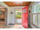 Bright entryway features a vibrant red door, wood plank ceiling, and tile flooring at 421 W 10Th Ave, Mount Dora, FL 32757