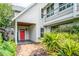 Inviting home entrance with a red door, complemented by vibrant greenery and a brick path at 421 W 10Th Ave, Mount Dora, FL 32757