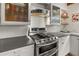 Kitchen with stainless steel oven and cooktop and glass-front cabinets for storage and display at 421 W 10Th Ave, Mount Dora, FL 32757