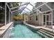 In-ground screened pool featuring clear blue water, tile, stone and steps at 421 W 10Th Ave, Mount Dora, FL 32757