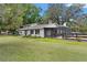View of the backyard with a covered screened-in patio and neutral exterior of the house at 43411 State Road 19, Altoona, FL 32702