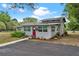 Charming one-story home with a red front door, well-maintained landscaping, and a paved walkway at 43411 State Road 19, Altoona, FL 32702