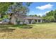 Charming home with neutral exterior paint, mature landscaping and sitting area on front porch at 43411 State Road 19, Altoona, FL 32702