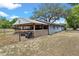 Rear exterior of the home with an attached covered shelter area for equipment and outdoor projects at 43411 State Road 19, Altoona, FL 32702