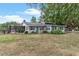 Rear view of home with neutral exterior paint, screened-in porch and fenced pasture at 43411 State Road 19, Altoona, FL 32702