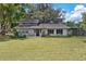Home exterior boasts a well-kept lawn, flowerbeds, and charming front entry at 43411 State Road 19, Altoona, FL 32702