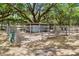 View of a fenced storage building with mature trees providing shade at 43411 State Road 19, Altoona, FL 32702