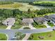 Aerial view of a yellow single-Gathering home with a two-car garage, mature trees, and well-maintained landscaping at 4547 Inverness Dr, Leesburg, FL 34748