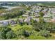 Aerial view of single-story home with screened pool, green lawn and landscaping; community with lake views in the background at 4547 Inverness Dr, Leesburg, FL 34748