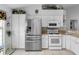 Well-lit kitchen showcasing stainless steel refrigerator, oven, microwave, and abundant white cabinetry at 4547 Inverness Dr, Leesburg, FL 34748