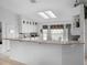 Well-lit kitchen showcasing granite counters, white cabinets, and a breakfast bar for casual dining at 4547 Inverness Dr, Leesburg, FL 34748