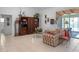 Comfortable living room showcasing tile floors, a cozy plaid sofa, and access to a screened lanai at 4547 Inverness Dr, Leesburg, FL 34748