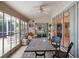 Enclosed sunroom with glass windows, tile flooring, ceiling fan, and furniture at 4547 Inverness Dr, Leesburg, FL 34748