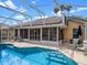 Inviting screened-in pool with sun chairs and lush landscaping provides a private outdoor retreat at 4547 Inverness Dr, Leesburg, FL 34748