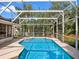 Inviting screened-in pool with sun chairs and lush landscaping provides a private outdoor retreat at 4547 Inverness Dr, Leesburg, FL 34748