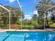 Inviting screened-in pool with lush landscaping provides a private outdoor retreat at 4547 Inverness Dr, Leesburg, FL 34748