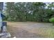 Large backyard featuring mature trees, offering privacy and a serene outdoor space at 522 Saint Andrews Blvd, Lady Lake, FL 32159
