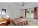 Cozy bedroom featuring a ceiling fan, two windows, and two bedside tables at 522 Saint Andrews Blvd, Lady Lake, FL 32159