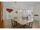 Dining room with stone table and view to the kitchen with white cabinets at 522 Saint Andrews Blvd, Lady Lake, FL 32159