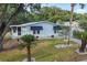 Charming single-story home featuring a manicured lawn, awning-covered windows, and a covered carport at 522 Saint Andrews Blvd, Lady Lake, FL 32159