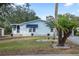 Charming single-story home featuring light blue siding, blue awnings, and well-maintained landscaping at 522 Saint Andrews Blvd, Lady Lake, FL 32159