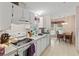 Kitchen featuring white appliances and cabinets with view into breakfast nook at 522 Saint Andrews Blvd, Lady Lake, FL 32159