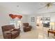 Spacious living room featuring plush armchairs, carpet and sliding glass doors at 522 Saint Andrews Blvd, Lady Lake, FL 32159