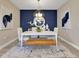 Dining room with navy accent wall, modern chandelier, white table with seating, and decorative artwork at 5463 Nickerbean St, Apopka, FL 32712