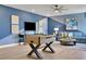 Modern game room with a foosball table, blue accent wall, and comfortable seating area at 5463 Nickerbean St, Apopka, FL 32712