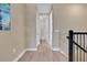 Bright hallway with wood floors leading to a bathroom featuring decorative tile at 5463 Nickerbean St, Apopka, FL 32712