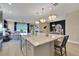 Spacious kitchen island with quartz countertops, seating, stylish pendant lights, and stainless steel sink at 5463 Nickerbean St, Apopka, FL 32712