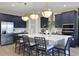Modern kitchen with navy cabinets, stainless steel refrigerator, white quartz island with sink, and stylish pendant lighting at 5463 Nickerbean St, Apopka, FL 32712