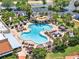 Aerial view of a community pool, highlighting the palm trees, waterfall feature, and seating areas at 741 Royal Palm Ave, Lady Lake, FL 32159
