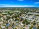 Expansive aerial view of a residential community featuring well-maintained homes, green spaces, and a scenic lake nearby at 8069 Se 174Th Ludlow Pl, The Villages, FL 32162