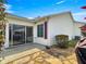 Exterior view of the home's backyard, showing sliding glass door access and neat landscaping at 8069 Se 174Th Ludlow Pl, The Villages, FL 32162