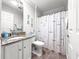 Bathroom features a white vanity with a granite countertop and a shower with a curtain at 8069 Se 174Th Ludlow Pl, The Villages, FL 32162