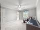 Bedroom features neutral walls, carpet flooring, a ceiling fan and a leather chair at 8069 Se 174Th Ludlow Pl, The Villages, FL 32162