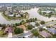 Stunning aerial view of a residential neighborhood featuring waterfront homes and mature trees around a tranquil lake at 8167 Bridgeport Bay Cir, Mount Dora, FL 32757