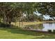 A serene backyard view features a tranquil lake, lush trees, and well-maintained landscaping at 8167 Bridgeport Bay Cir, Mount Dora, FL 32757