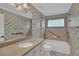 Bright bathroom with a tub, vanity, and a decorative mirror, creating a relaxing and functional space at 8167 Bridgeport Bay Cir, Mount Dora, FL 32757