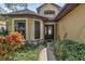 Charming front entrance with decorative door, stone accents, and lush landscaping at 8167 Bridgeport Bay Cir, Mount Dora, FL 32757