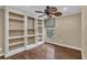 Well-lit home office/study with built-in bookshelves, hardwood floors, neutral walls and a modern ceiling fan at 8167 Bridgeport Bay Cir, Mount Dora, FL 32757