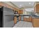 Cozy kitchen featuring stainless steel appliances, wooden cabinets, and tile flooring, all within an open layout at 8167 Bridgeport Bay Cir, Mount Dora, FL 32757