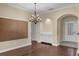 Dining area with elegant chandelier, neutral walls, and easy access to the kitchen and main entrance at 8167 Bridgeport Bay Cir, Mount Dora, FL 32757