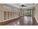 Bright living room featuring hardwood floors, neutral walls, and sliding glass doors leading to a screened patio at 8167 Bridgeport Bay Cir, Mount Dora, FL 32757