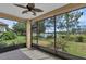 Relaxing screened-in porch with ceiling fan, offering picturesque views of the serene lake and lush greenery at 8167 Bridgeport Bay Cir, Mount Dora, FL 32757