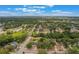 Lush trees abound in this delightful neighborhood, seen from an aerial view under a brilliant blue sky filled with puffy clouds at 8410 Lake Bosse Dr, Orlando, FL 32810