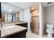 Bathroom featuring a double vanity with granite countertops and a shower with decorative tile accents at 8410 Lake Bosse Dr, Orlando, FL 32810