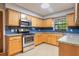 Updated kitchen with wood cabinets, granite countertops, stainless steel appliances, and modern backsplash at 8410 Lake Bosse Dr, Orlando, FL 32810
