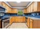 Well-lit kitchen featuring wood cabinets, stainless steel appliances, modern backsplash, and granite countertops at 8410 Lake Bosse Dr, Orlando, FL 32810